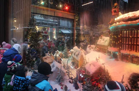 Các em bé thích thú xem trưng bày trước một cửa hiệu bán quà Noel